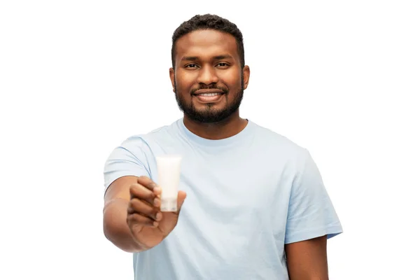 Homem americano africano feliz mostrando hidratante — Fotografia de Stock