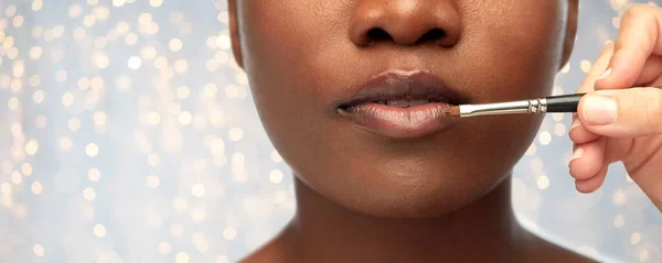 Rosto de mulher africana e mão com maquiagem escova — Fotografia de Stock