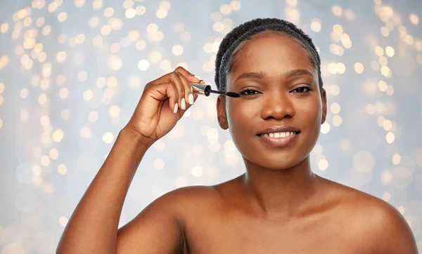 Mooie afrikaanse amerikaanse vrouw toepassen mascara — Stockfoto