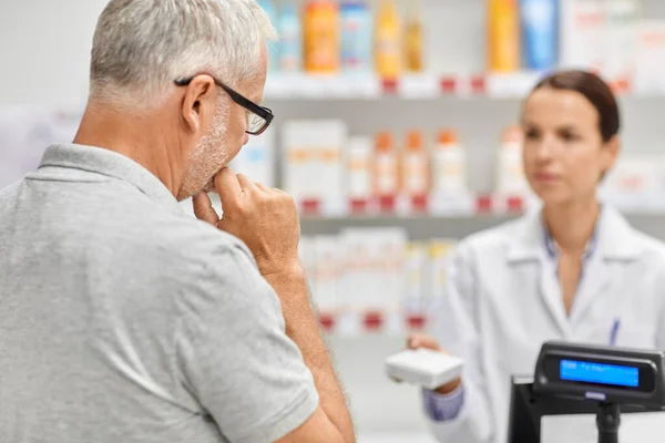 Farmacéutico y hombre viejo con la medicina en la farmacia —  Fotos de Stock
