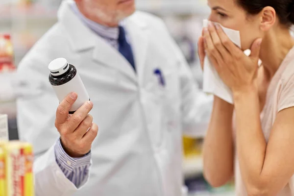 Apotheker toont geneeskunde aan zieke vrouw in de apotheek — Stockfoto