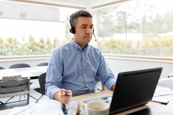 Hombre con auriculares y portátil trabajando en casa — Foto de Stock