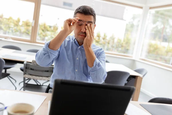 Uomo stanco con computer portatile che lavora a casa ufficio — Foto Stock