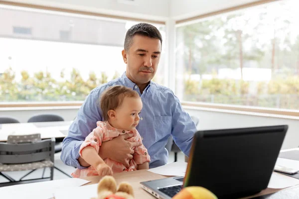 Tată cu bebeluș care lucrează la laptop la birou — Fotografie, imagine de stoc