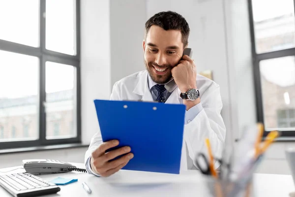 Médico masculino chamando no telefone mesa no hospital — Fotografia de Stock