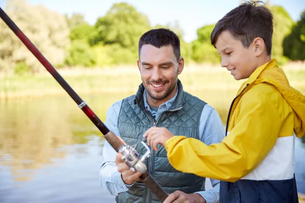 Feliz sorrindo pai e filho pesca no rio — Fotografia de Stock