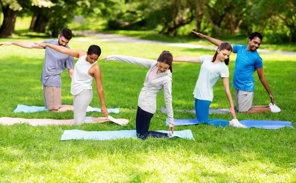 Grupo de pessoas fazendo ioga no parque de verão — Fotografia de Stock