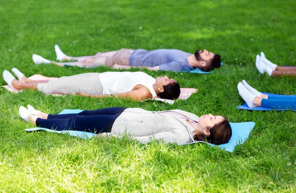 Group of people doing yoga at summer park — Stock Photo, Image