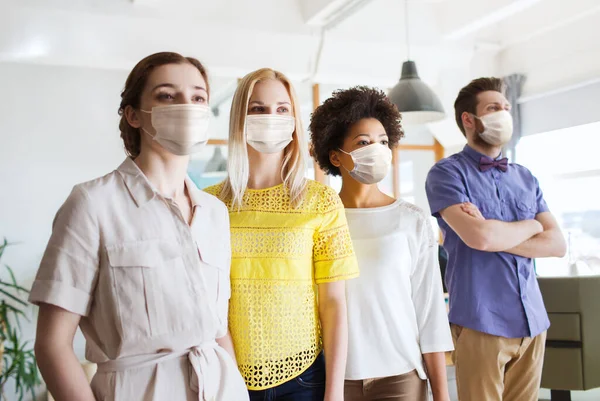 Affärsteam i masker på kontoret — Stockfoto