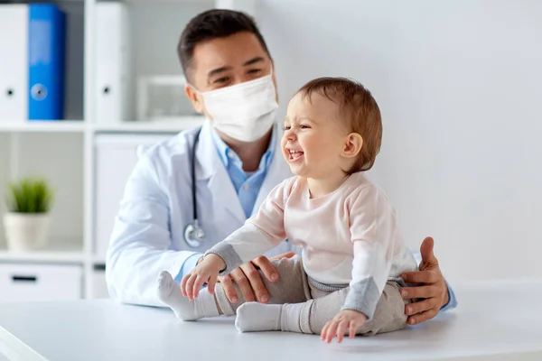 Médico o pediatra con máscara de bebé en la clínica — Foto de Stock