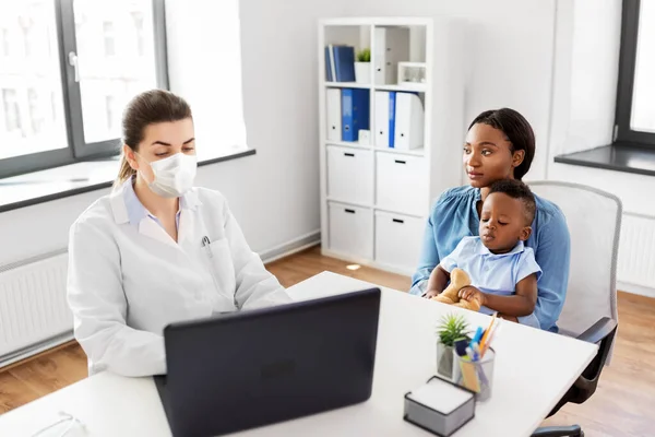 Matka, dítě a lékař v masce s notebookem — Stock fotografie