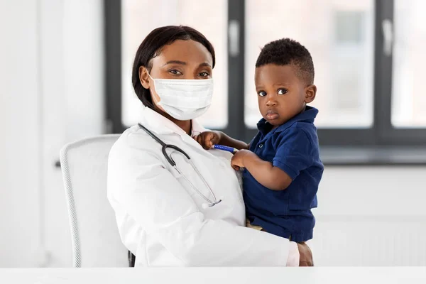 Doctor en máscara con bebé paciente en la clínica — Foto de Stock