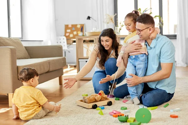 Happy family palying with wooden toys at home — Stock Photo, Image