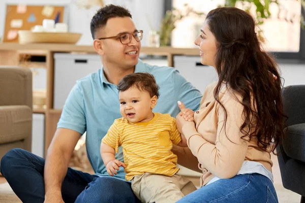 Familia feliz con el niño sentado en el sofá en casa —  Fotos de Stock