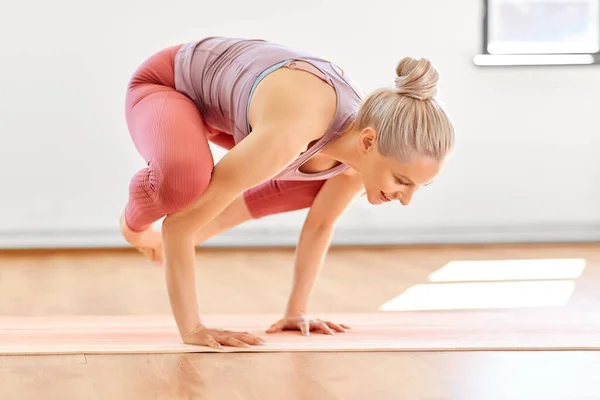 Jonge vrouw doen kraan poseren in yoga studio — Stockfoto