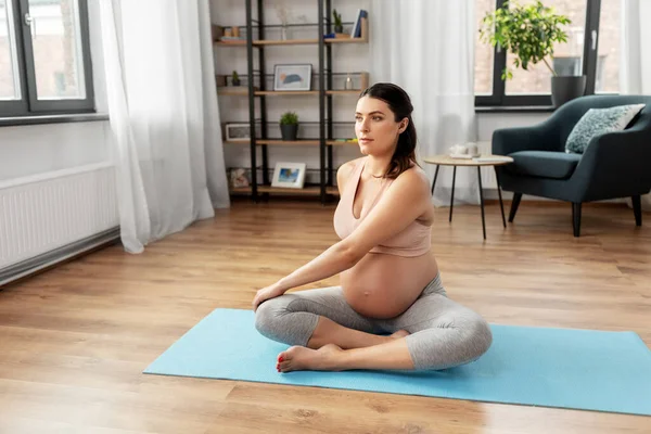 Mujer embarazada feliz haciendo yoga en casa —  Fotos de Stock