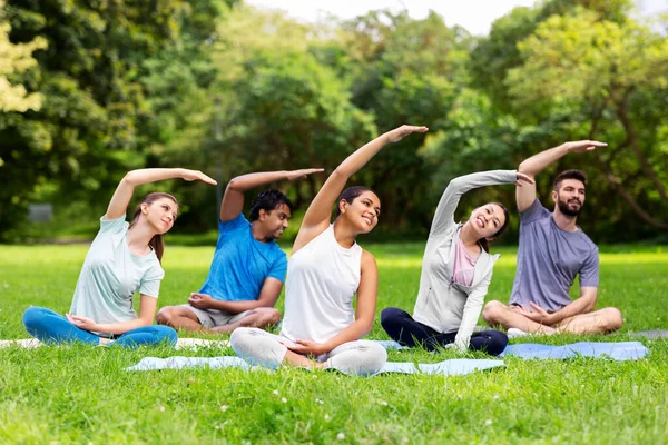 Grupp människor motionerar på sommarparken — Stockfoto