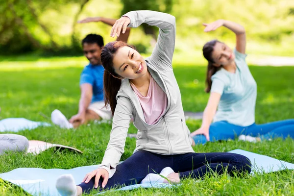 Grupp människor motionerar på sommarparken — Stockfoto