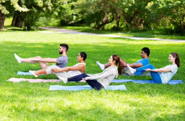 Group of people doing yoga at summer park — Stock Photo, Image