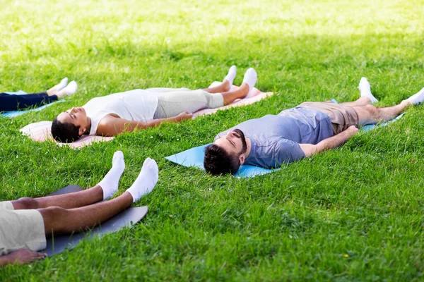 Groep mensen die yoga doen in het zomerpark — Stockfoto