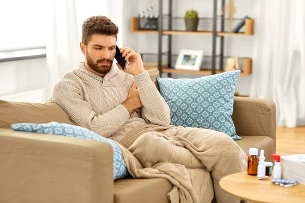 Хворий молодий чоловік телефонує на смартфон вдома — стокове фото