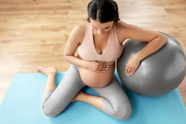 Mujer embarazada feliz con fitball en casa Imagen De Stock