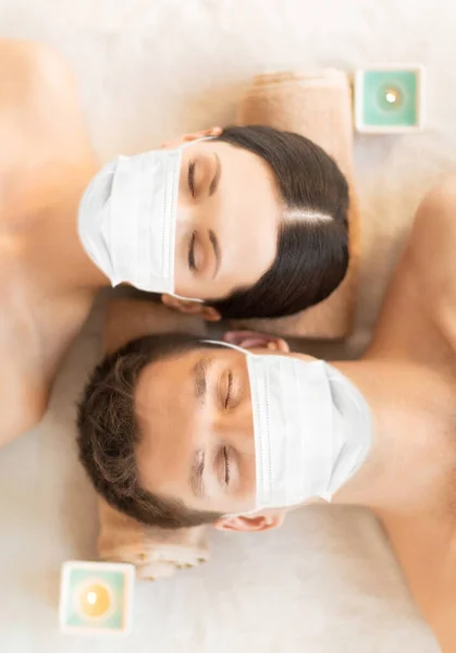 Пара в масках на ароматерапии на курортном сеансе — стоковое фото