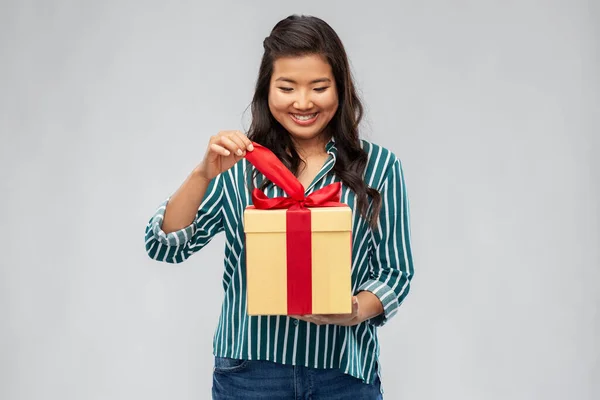 Счастливая азиатка, открывающая подарочную коробку — стоковое фото
