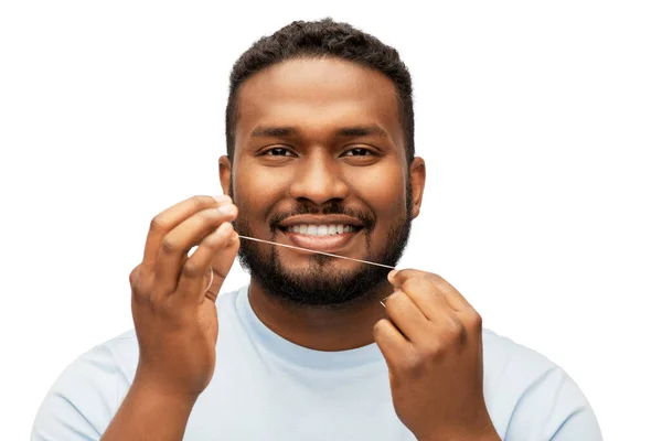 Homem africano feliz com fio dental dentes de limpeza — Fotografia de Stock