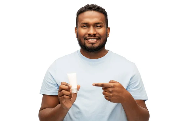 Hombre afroamericano feliz mostrando crema hidratante —  Fotos de Stock