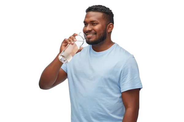 Felice uomo africano bere acqua dalla bottiglia di vetro — Foto Stock