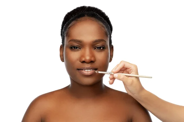 Gezicht van Afrikaanse vrouw en hand met make-up borstel — Stockfoto
