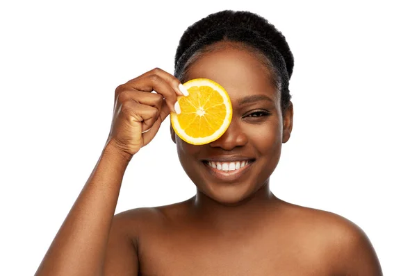 Lächelnde Afrikanerin macht Augenmaske aus Orangen — Stockfoto