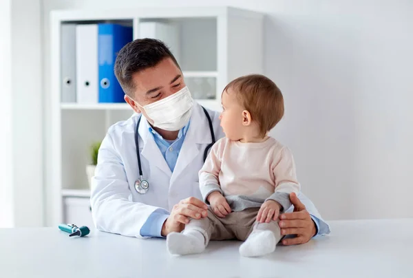 Médico o pediatra con máscara de bebé en la clínica —  Fotos de Stock