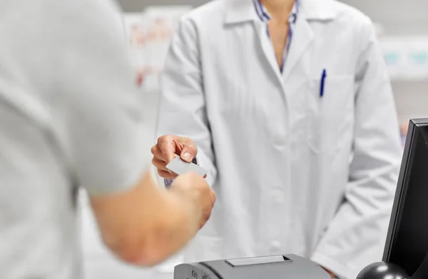 Close up of hand giving bank card to pharmacist — Stock Photo, Image