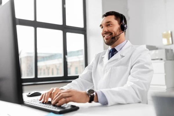 Médecin heureux avec ordinateur et casque à l'hôpital — Photo