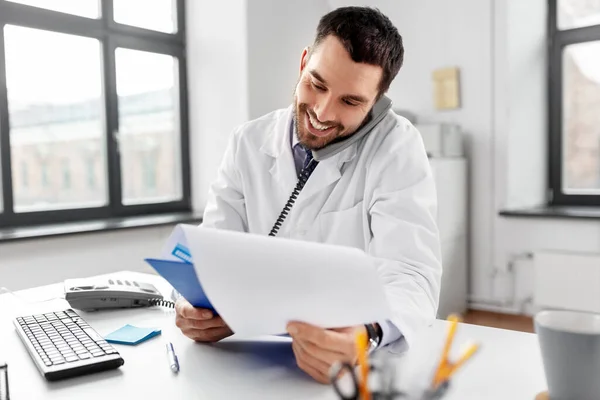 Médecin masculin appelant sur le téléphone de bureau à l'hôpital — Photo