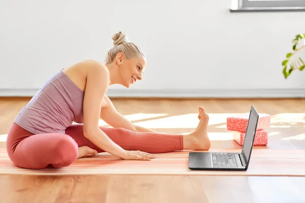 Donna con computer portatile che esercita presso lo studio di yoga — Foto Stock