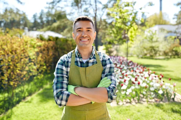 Щасливий чоловік в фартусі в літньому саду — стокове фото