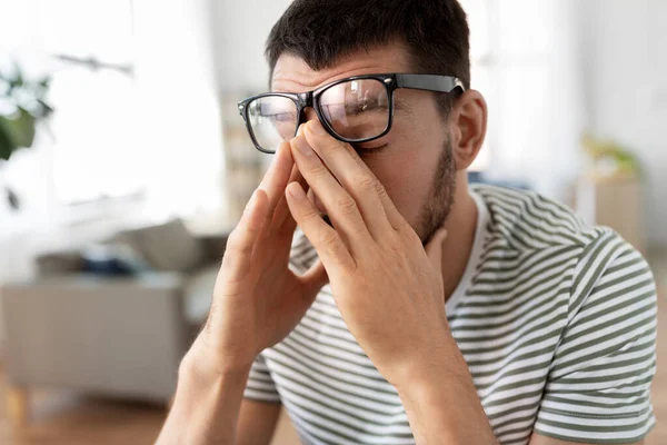 Втомлений чоловік в окулярах в домашньому офісі — стокове фото