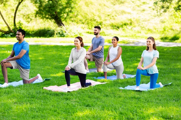 Groep mensen die yoga doen in het zomerpark — Stockfoto