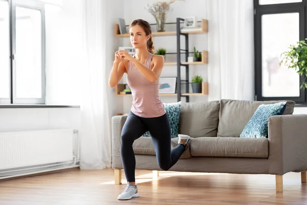 Mujer joven haciendo ejercicio en casa — Foto de Stock