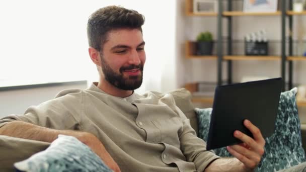 Hombre con Tablet PC que tiene videollamada en casa — Vídeos de Stock