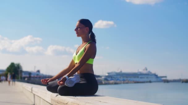 Jeune femme méditant dans la pose de lotus au bord de la mer — Video