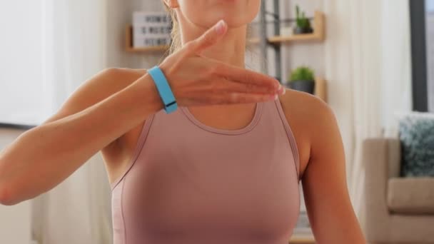 Donna con fitness tracker che fa yoga a casa — Video Stock