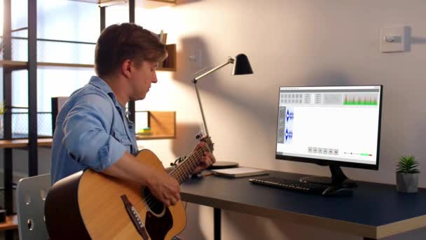 Mann spielt zu Hause Gitarre und nimmt Musik auf — Stockvideo