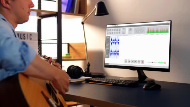 Hombre tocando la guitarra y grabando música en casa — Vídeo de stock