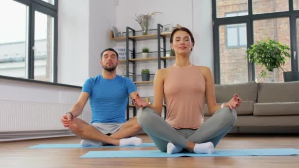Couple méditant dans la pose de lotus yoga à la maison — Video