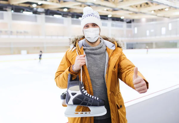 Man in mask showing thumbs up on skating rink — Stock Photo, Image