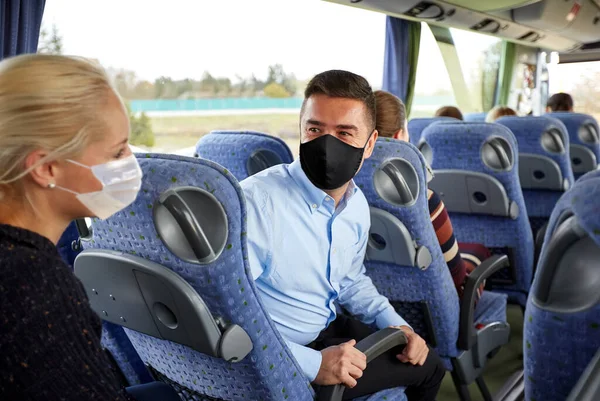 Пассажиры в масках говорят в туристическом автобусе — стоковое фото